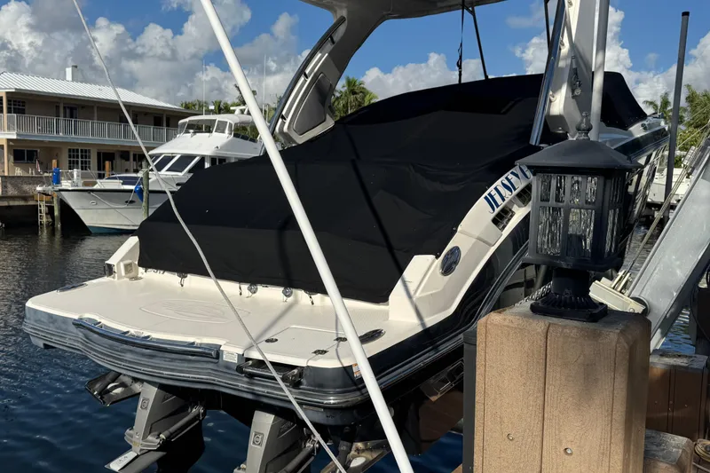 Slide: The Image of 2019 Chaparral 317 SSX boat docked, covered , near waterfront homes. - 3