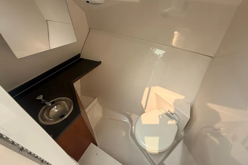 Slide: The Image of 2025 Pursuit DC 306 Dual Console boat bathroom with sink and toilet. - 22