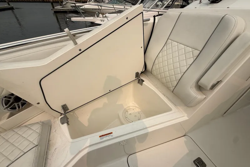Slide: The Image of 2025 Pursuit DC 306 Dual Console boat with open storage compartment and quilted seating. - 34