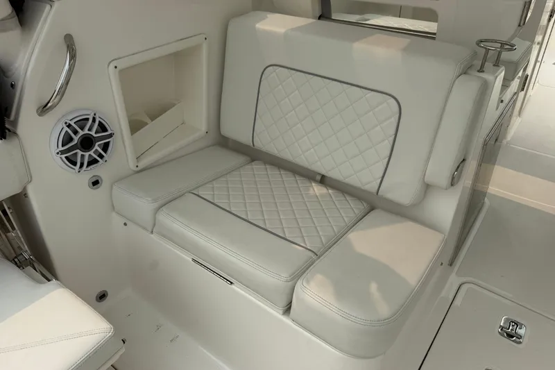Slide: The Image of Luxurious seating on 2025 Pursuit DC 306 Dual Console boat with quilted upholstery and built-in speaker. - 16