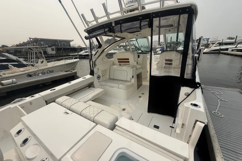 Slide: The Image of 2025 Pursuit DC 306 Dual Console boat docked at marina, featuring spacious seating and modern design. - 6