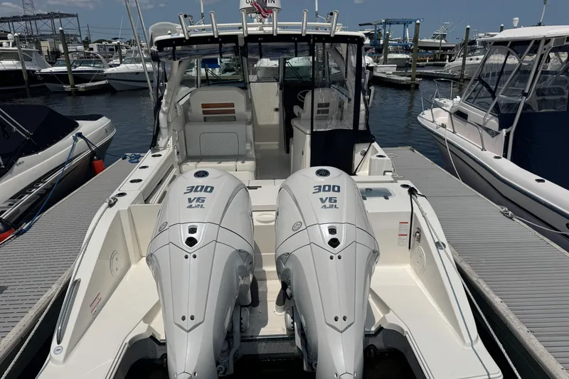 Slide: The Image of 2025 Pursuit DC 306 Dual Console boat with twin 300 V6 engines docked at marina. - 5
