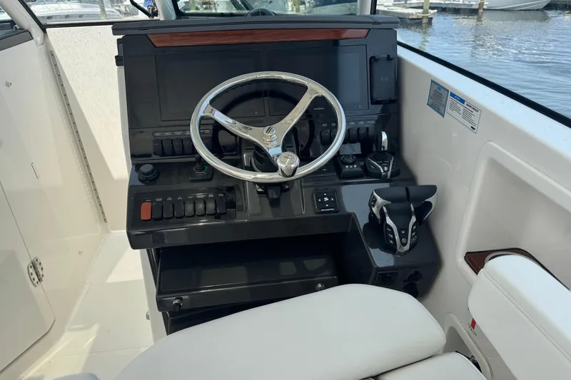 Slide: The Image of Cockpit of 2025 Pursuit DC 306 Dual Console boat with modern controls and steering wheel. - 26