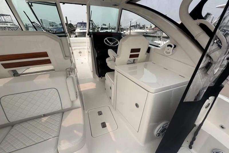 Slide: The Image of Interior of 2025 Pursuit DC 306 Dual Console boat, featuring luxurious seating and helm area. - 12