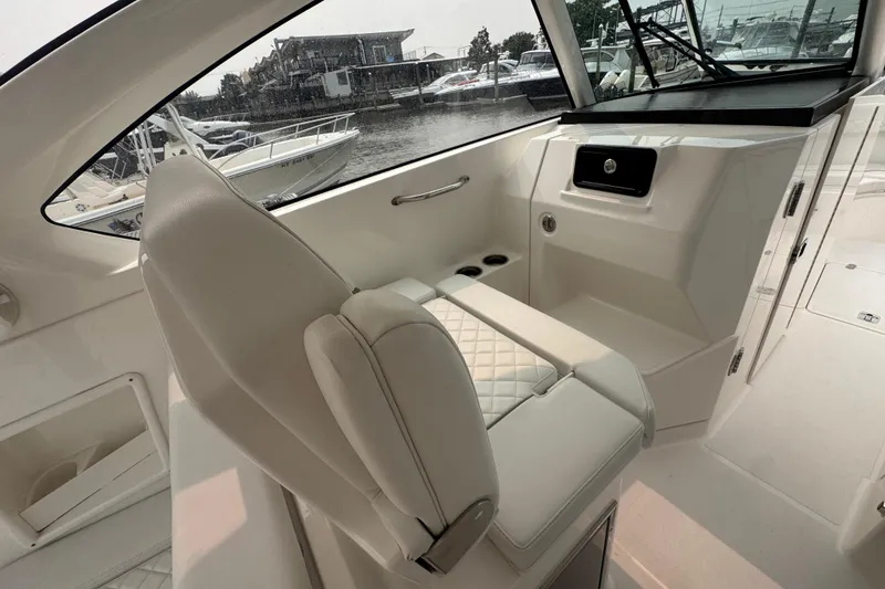 Slide: The Image of 2025 Pursuit DC 306 Dual Console interior with luxurious seating and modern dashboard. - 18