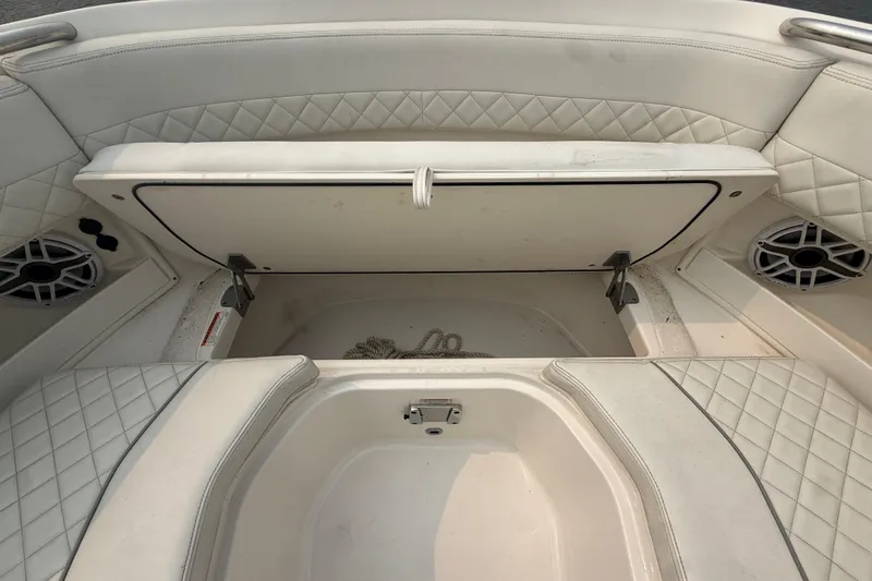 Slide: The Image of 2025 Pursuit DC 306 Dual Console boat interior with open storage compartment and quilted seating. - 30