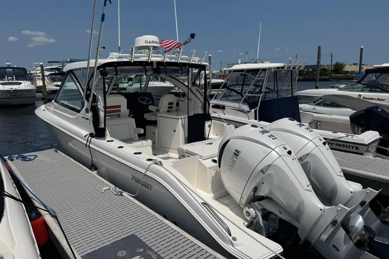 Slide: The Image of 2025 Pursuit DC 306 Dual Console boat docked with twin Yamaha engines. - 3