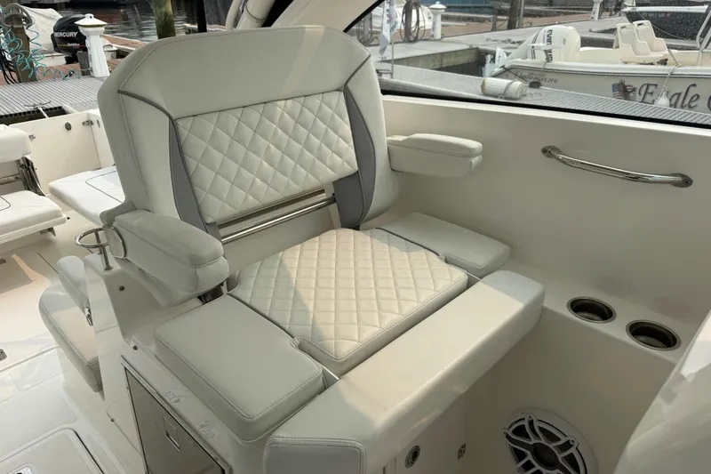 Slide: The Image of Luxurious seating on 2025 Pursuit DC 306 Dual Console boat, featuring quilted upholstery and armrests. - 19