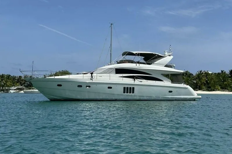 The Image of 2008 Princess 67 Flybridge Motor Yacht on tranquil blue water near a tropical shoreline. - 0