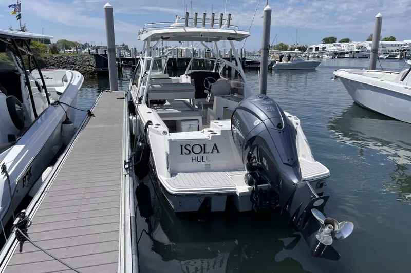 Slide: The Image of 2023 Solara S-250 DC boat docked at marina, featuring powerful outboard engine. - 6