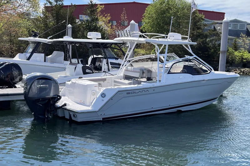 The Image of 2023 Solara S-250 DC boat docked in marina, featuring sleek design and Yamaha outboard motor. - 1