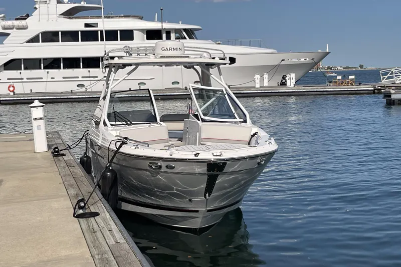 Slide: The Image of 2023 Solara S-250 DC boat docked at marina, with luxury yacht in background. - 4