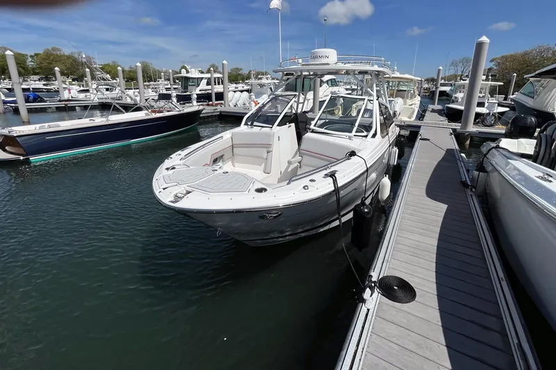 Slide: The Image of 2023 Solara S-250 DC boat docked at a marina under a clear blue sky. - 3