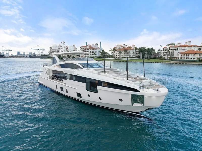 The Image of Azimut Grande 32 Metri 2022 yacht cruising near luxury waterfront residences. - 0