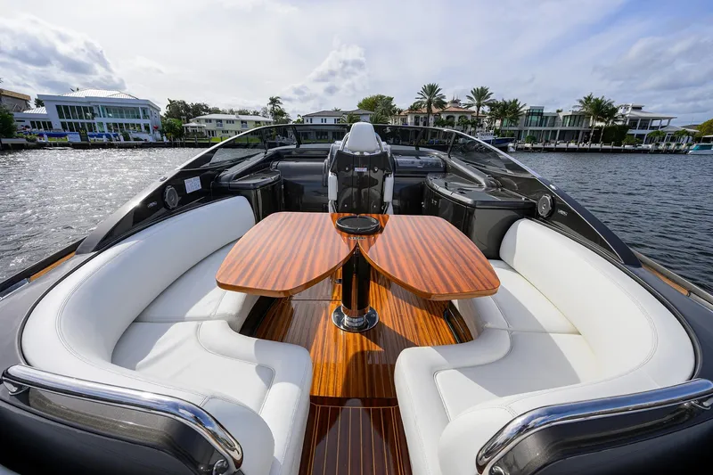 Slide: The Image of Luxurious 2014 Riva 44' Rivarama yacht with elegant seating and wooden table on a scenic waterway. - 59