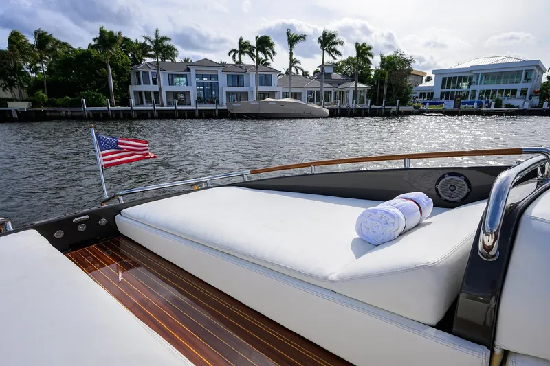Slide: The Image of Luxurious 2014 Riva 44' Rivarama yacht with American flag, docked near waterfront homes. - 88
