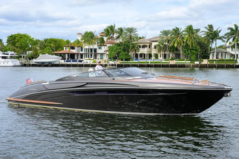 The Image of 2014 Riva 44' Rivarama luxury yacht cruising near waterfront homes with palm trees. - 0