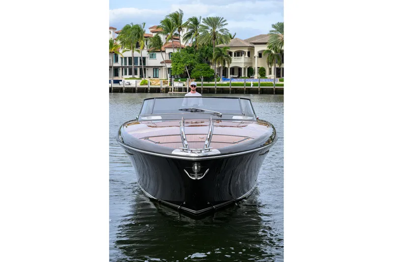 Slide: The Image of 2014 Riva 44' Rivarama luxury yacht on water, with waterfront homes in background. - 16