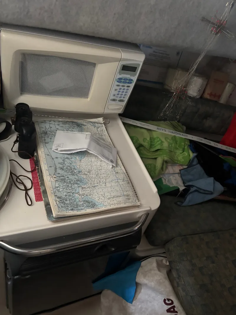 Slide: The Image of A boat cabin with a microwave, nautical charts, and binoculars on a table. - 4