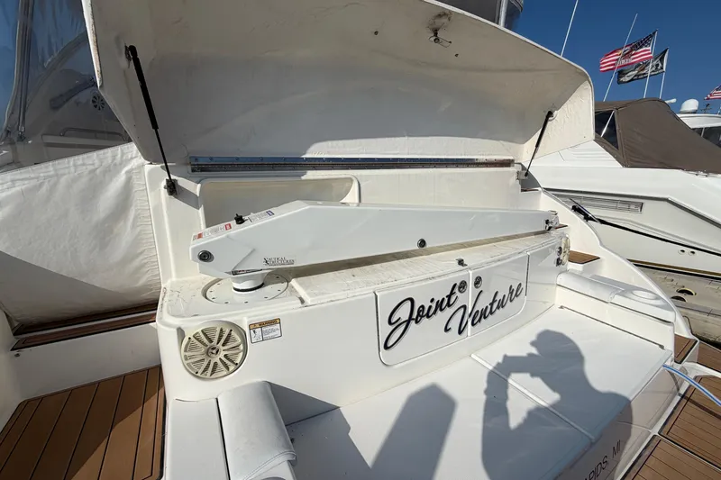 Slide: The Image of 2003 Cruisers Yachts 5470 Express with open hatch and "Joint Venture" nameplate. - 5
