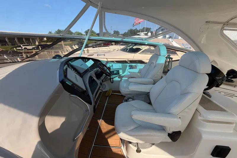 Slide: The Image of 2003 Cruisers Yachts 5470 Express cockpit with white leather seats and modern dashboard. - 17