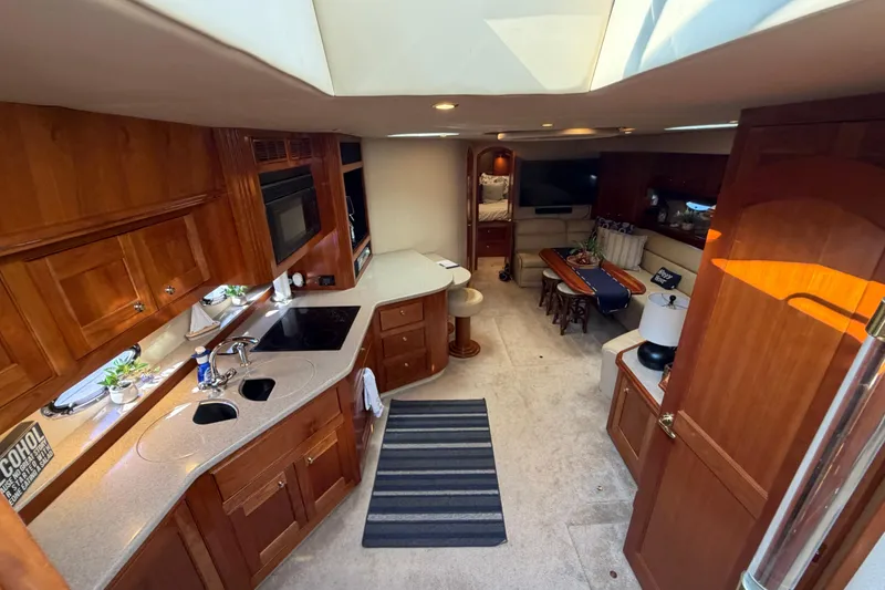 Slide: The Image of Luxurious interior of 2003 Cruisers Yachts 5470 Express with modern kitchen and cozy seating area. - 24