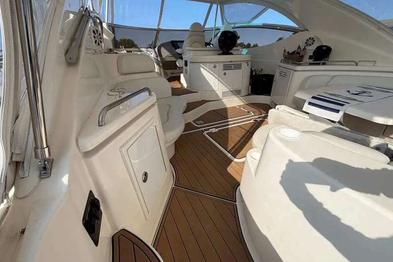 Slide: The Image of 2003 Cruisers Yachts 5470 Express interior with white seating and wood flooring. - 6