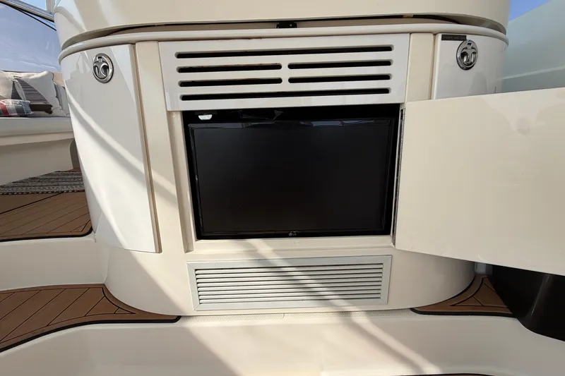 Slide: The Image of 2003 Cruisers Yachts 5470 Express interior with built-in TV and seating area. - 13