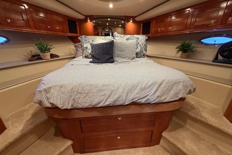 Slide: The Image of Luxurious 2003 Cruisers Yachts 5470 Express cabin interior with cozy bed and elegant wood finish. - 30