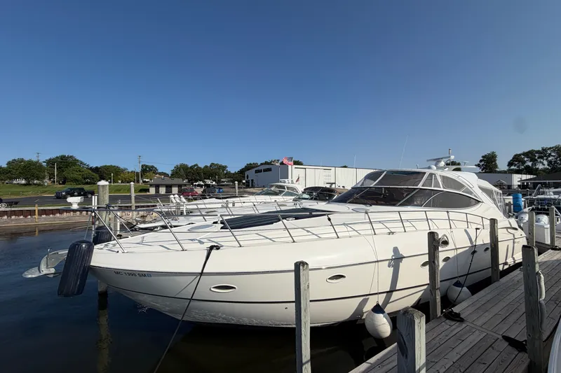 Slide: The Image of 2003 Cruisers Yachts 5470 Express docked at marina under clear blue sky. - 3