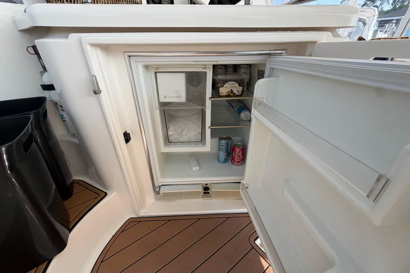 Slide: The Image of Open refrigerator on 2003 Cruisers Yachts 5470 Express, stocked with drinks and snacks. - 10