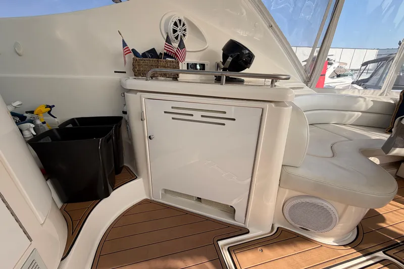 Slide: The Image of 2003 Cruisers Yachts 5470 Express interior with seating, storage, and American flags. - 9