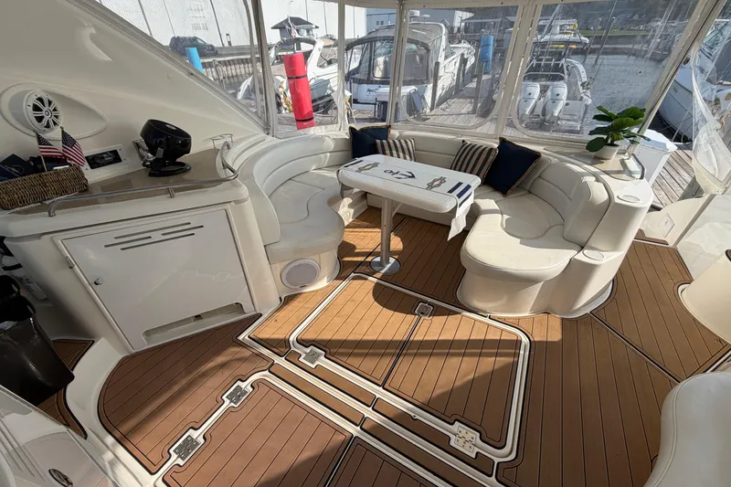 Slide: The Image of Luxurious 2003 Cruisers Yachts 5470 Express interior with elegant seating and wooden flooring. - 8