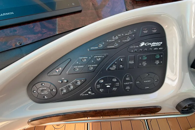 Slide: The Image of Control panel of a 2003 Cruisers Yachts 5470 Express with various switches and buttons. - 18