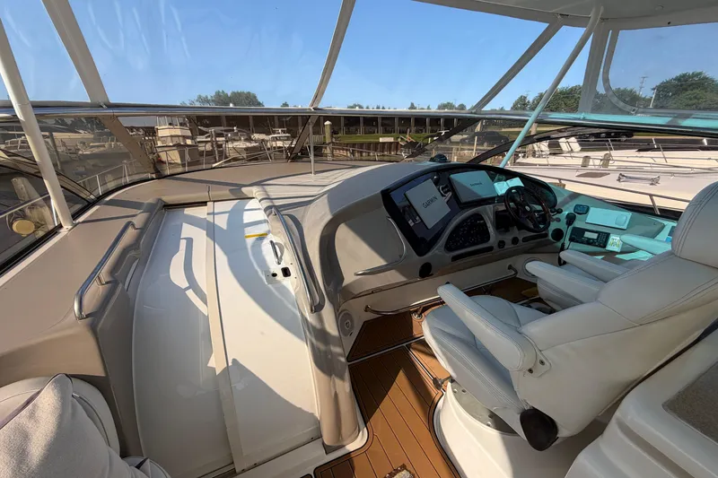 Slide: The Image of 2003 Cruisers Yachts 5470 Express helm with modern navigation equipment and luxurious seating. - 16