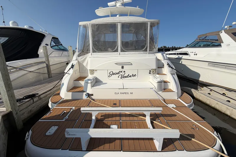 Slide: The Image of 2003 Cruisers Yachts 5470 Express docked, rear view with teak deck and enclosed cockpit. - 4