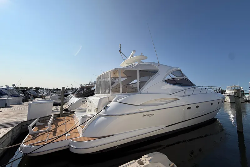 Slide: The Image of 2003 Cruisers Yachts 5470 Express docked at marina under clear blue sky. - 1