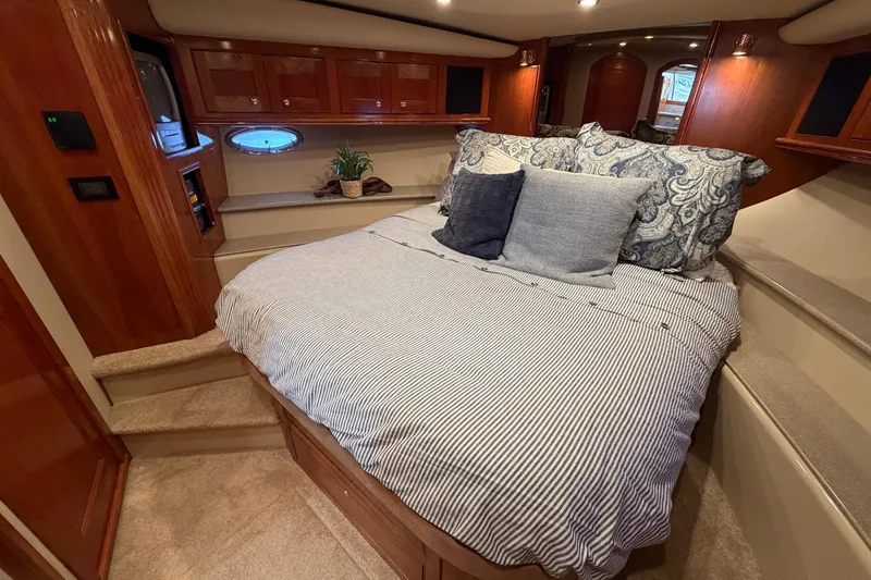 Slide: The Image of Luxurious 2003 Cruisers Yachts 5470 Express cabin with cozy bed and elegant wood finishes. - 31