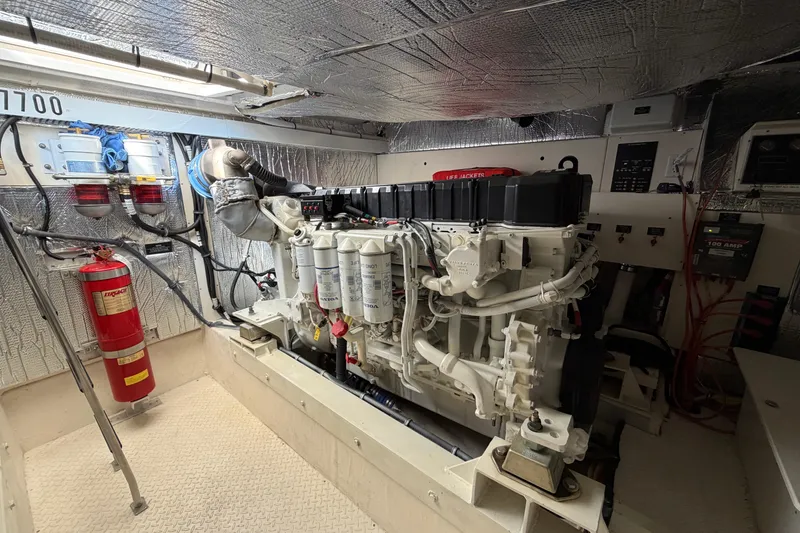 Slide: The Image of Engine room of 2003 Cruisers Yachts 5470 Express with visible machinery and fire extinguisher. - 42