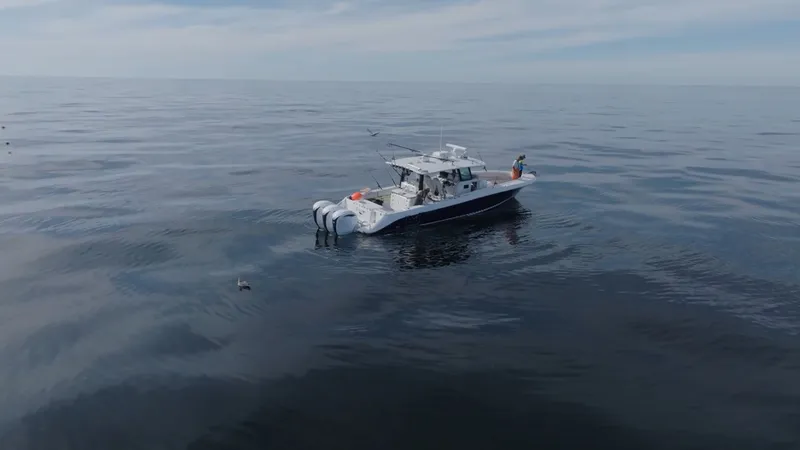 Slide: The Image of A 2023 HCB 42 Lujo on calm water with multiple outboard engines. - 11