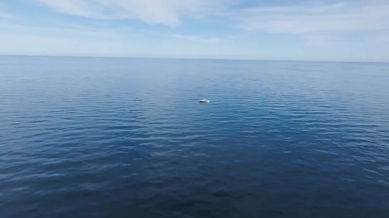Slide: The Image of A small boat on calm, blue water under a clear sky. - 21