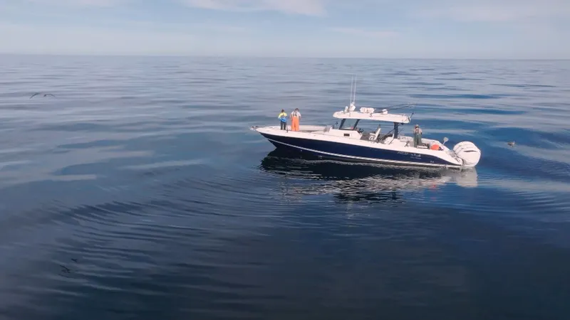 Slide: The Image of A 2023 HCB 42 Lujo cruising on calm waters. Several people are on board. - 8