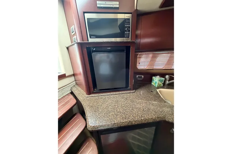 Slide: The Image of 2007 Sea Ray 380 Sundancer galley with microwave, fridge, and countertop. - 26