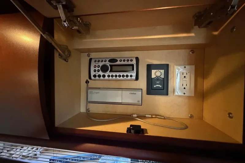 Slide: The Image of Control panel inside 2007 Sea Ray 380 Sundancer yacht, featuring audio system and power outlet. - 25