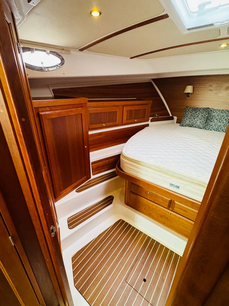 Slide: The Image of The 2018 Back Cove 37 cabin features a cozy bed and wooden furnishings. - 33
