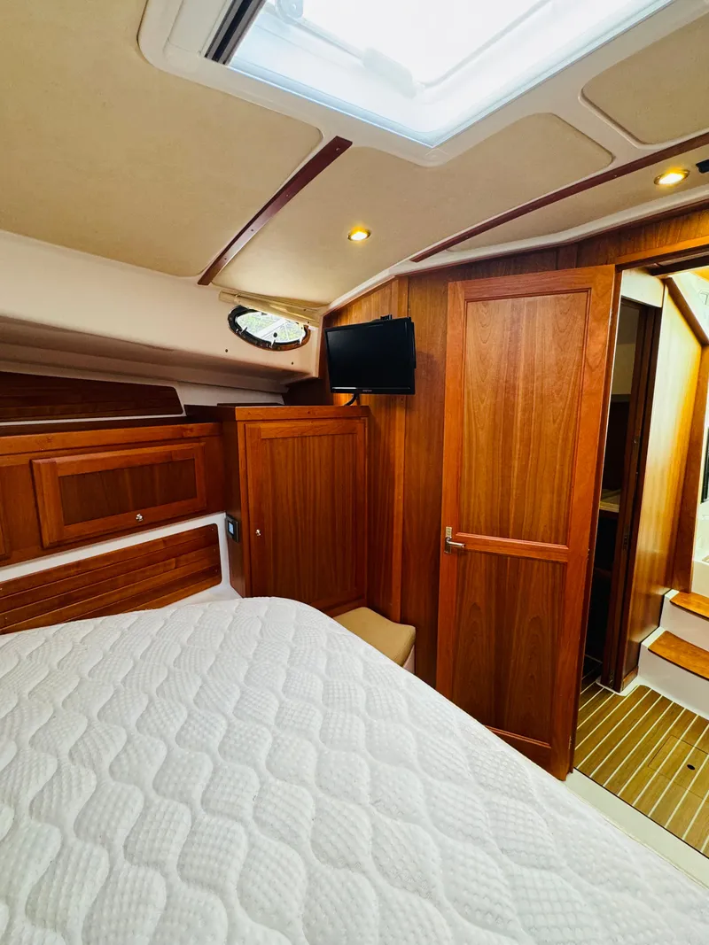 Slide: The Image of Interior of a 2018 Back Cove 37 with wood paneling and a bed. - 35