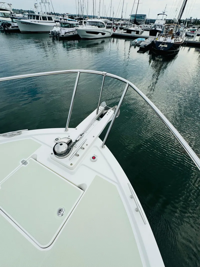 Slide: The Image of The 2018 Back Cove 37 is docked in a busy marina. The bow features a sleek design. - 16