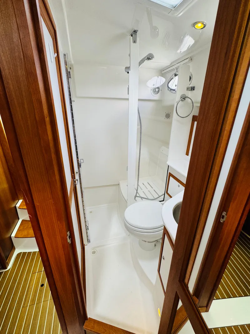 Slide: The Image of The image shows a modern boat bathroom with a shower, toilet, and sink. - 36
