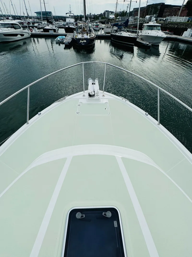 Slide: The Image of The 2018 Back Cove 37 is docked in a marina, surrounded by other boats. - 14
