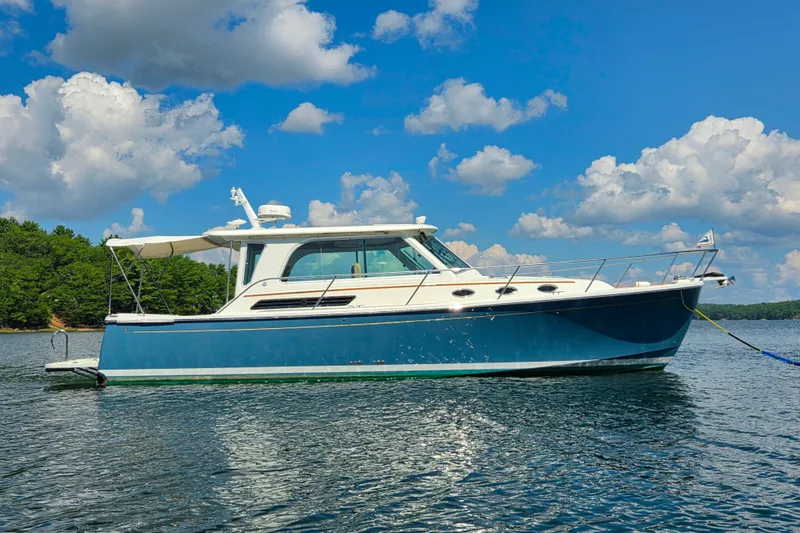 The Image of 2018 Back Cove 37 boat on calm water under a blue sky with clouds. - 0